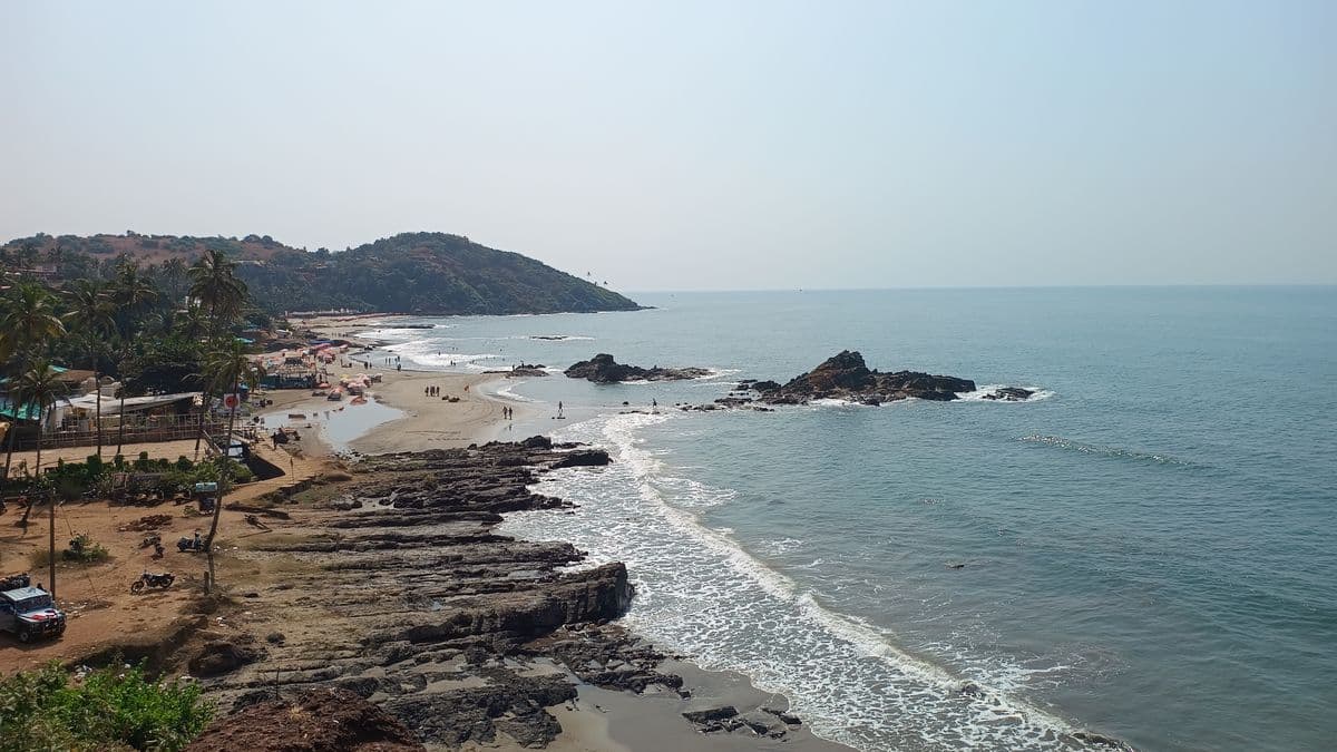 The rocky golden coastline of a North Goa beach.