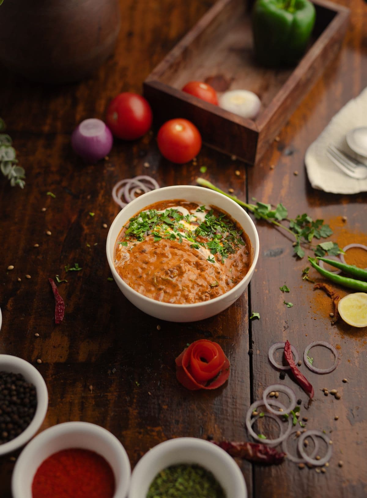 A bowl of dal makhani on a rustic wooden table.