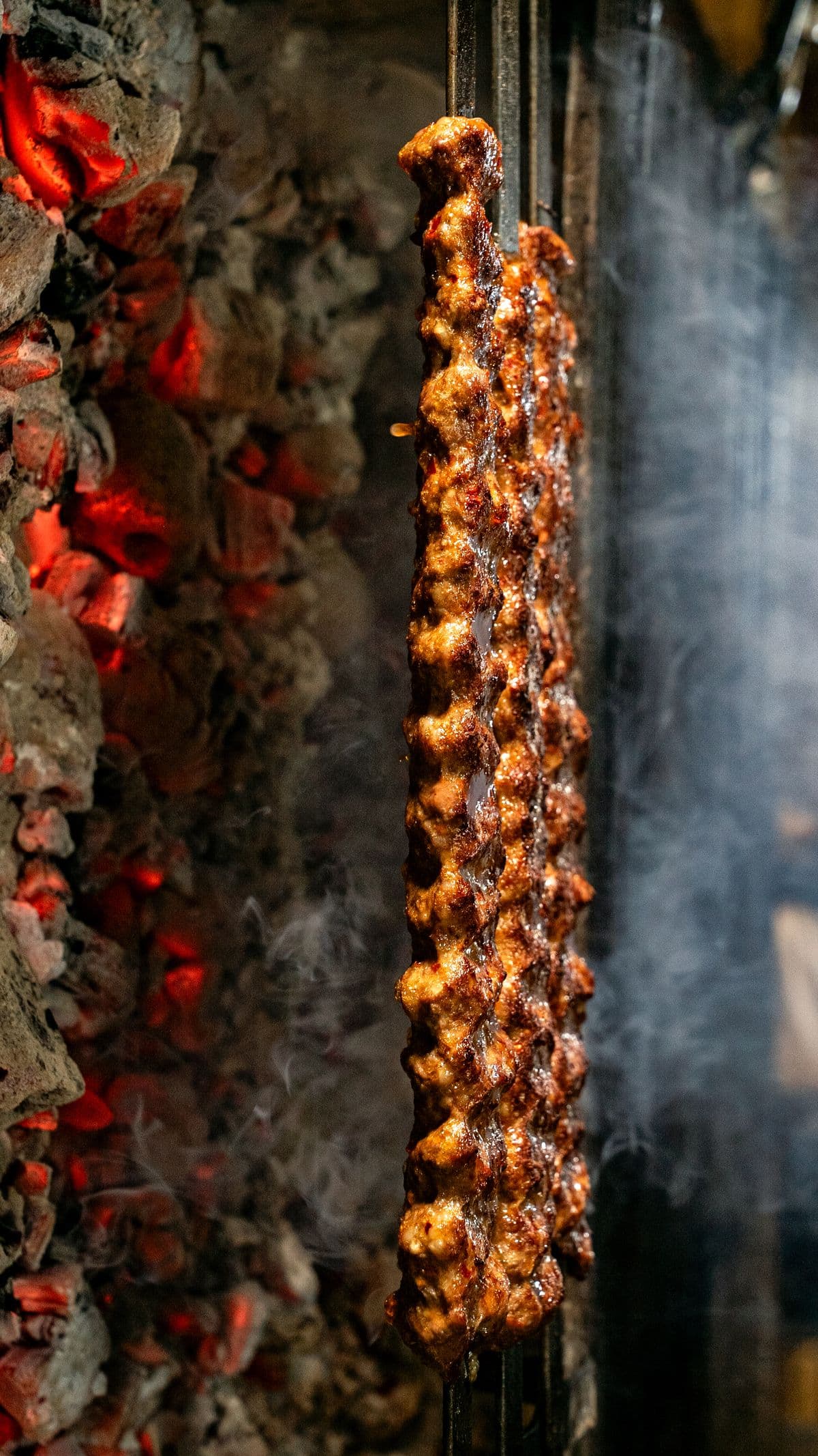 Skewers grilling over a glowing open flame.