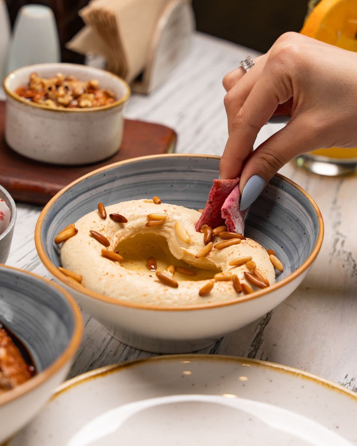 A Lebanese mezze of hummus, pine nuts and pita.